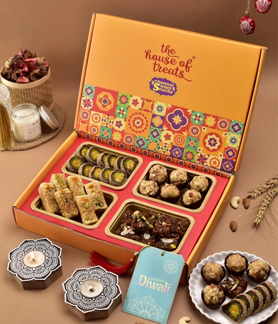 Best Diwali Homemade Sweet Boxes Online in Chennai A box filled with assorted sweets and snacks, featuring a decorative tag for a delightful touch.
