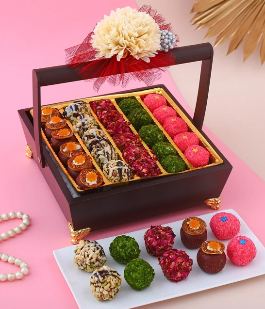 Diwali Gifts Hampers and Gift Box Dealers in Chennai A decorative plate holds a colorful assortment of sweets, alongside a beautifully wrapped gift box, exuding joy.