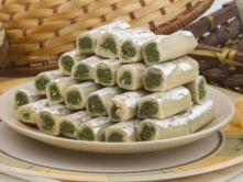 Traditional Kaju Pista Diwali Sweets in Chennai A plate of elegantly arranged green & white kaju pista rolls showcases their delicate texture and colors.